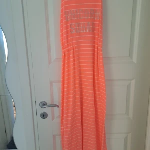 Orange randig klänning från Primark - Säljer en cool orange klänning från Primark med vita ränder och texten 'UNICORN SQUAD' i silver. Klänningen har en bekväm passform och är perfekt för sommarens äventyr. Den är ärmlös och har en elastisk midja för extra komfort.
