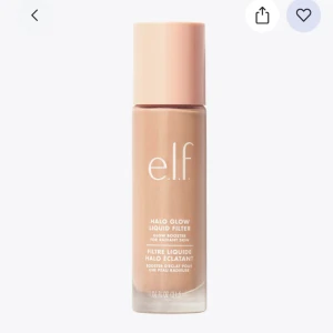 Halo Glow Liquid Filter från e.l.f. - Upptäck e.l.f. Halo Glow Liquid Filter, en flytande produkt som ger en strålande och jämn hudton. Förpackningen är elegant med en ljusrosa kork och transparent flaska som visar den beige nyansen. Perfekt för att skapa en naturlig glow.