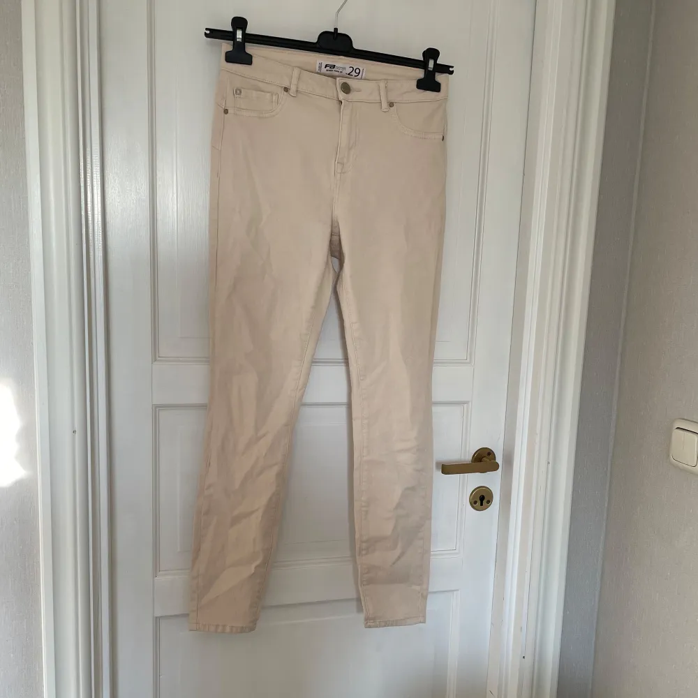 Snygga beige byxor med en klassisk design. De har en normal passform och är perfekta för en stilren look. . Farkut & Housut.