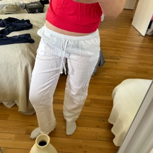 Vita linnebyxor med snörning - Ett par vita lågmidjade linnebyxor med snörning i midjan, jag är ca 168 cm lång och innerbenslängden borde vara ca 80 cm, fråga bara om det är något!!