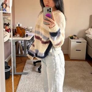 Randig stickad tröja från Cubus - Mysig stickad tröja från Cubus i storlek S. Tröjan har ett randigt mönster i beige, blått och vinrött. Den har långa ärmar och en avslappnad passform, perfekt för kyligare dagar.