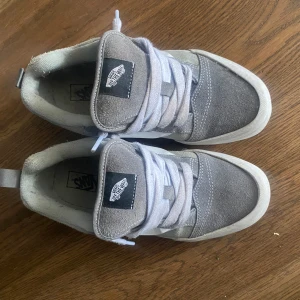 Grå sneakers från Vans,grey knu skool vans - Snygga grå sneakers från Vans med vit sula och klassisk sidostrip. Skorna har snörning och är tillverkade i mocka och syntetmaterial. Perfekta för en avslappnad stil.