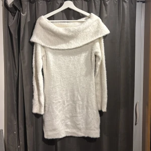Vit fluffig klänning från H&M - Säljer en supermjuk och fluffig vit klänning från H&M. Den är off shoulder och har långa ärmar, perfekt för kyligre dagar. Säljer för att den inte kommer till användning. Är använd en gång. Skriv gärna om eventuella frågor.❄️🌸