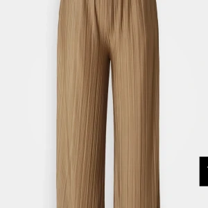 Beige plisserade byxor från Samsøe Samsøe - Snygga beige plisserade byxor från Samsøe Samsøe. De har en loose passform och är perfekta för en stilren look. Byxorna är högmidjade och tillverkade i ett lätt och bekvämt material. Knappt använt. 