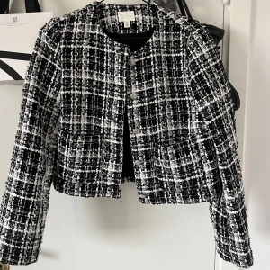 Svartvit rutig kofta/jacka - Snygg svartvit rutig kofta/jacka med snygga knappar framtill. Passar perfekt till våren. Är precis som ny, använd en gång! 