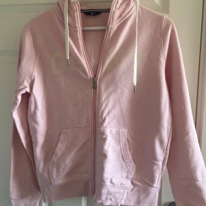 Rosa zip hoodie från Gant - Säljer en rosa ziphoodie från Gant i storlek S.     Den är i bra skick men har använts många gånger och dragkedjan funkar den ska😊