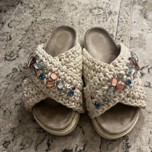 inuikii tofflor  - inuikii tofflor med färgglada stenar. Saknar inga stenar. Använda men fortfarande i bra skick. Storlek 39 men passar en 37/38 med då jag brukar ha de i skor! 