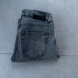 Grå jeans från Grunt - Snygga grå jeans från Grunt i en klassisk straight fit. De har en knappgylf och femficksdesign. Perfekta för en avslappnad stil med en touch av vintagekänsla.