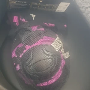 Skyddsutrustning för inlines, scooter och skateboard - Skyddsutrustning i svart och lila för juniorer, perfekt för inlines, scooter och skateboard. Setet innehåller knä-, armbågs- och handledsskydd. Kommer i en praktisk nätpåse för enkel förvaring.