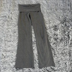 Grå byxor från Gina Tricot - Snygga grå byxor från Gina Tricot med en bekväm passform. Byxorna har en bred linning och vida ben, vilket ger en avslappnad look. Perfekta för en stilren vardagsoutfit. Det är en pytteliten fläck men man tänker inte på det