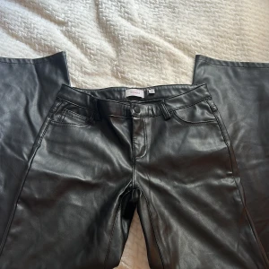 Svarta bootcut skinnbyxor från Vero Moda - Säljer dessa snygga svarta bootcut skinnbyxor från Vero Moda i storlek 12Y-152 som inte går att få tag på längre.