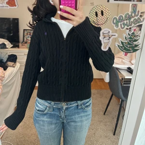 Svart stickad kofta med dragkedja - Såå snygg svart stickad ralph lauren kofta med dragkedja och kabelstickat mönster. Barn storlek 16 men passar mig som vanligtvis har xs-s