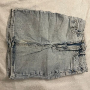 Ljusblå jeanskjol från Perfect Jeans - Säljer en snygg ljusblå jeanskjol från Perfect Jeans i modellen Molly. Kjolen har en klassisk design med femficksmodell och knappgylf. Perfekt för en avslappnad stil.