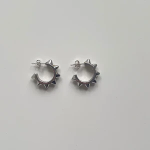 Örhängen från Edblad  - Säljer silverörhängen från Edblad. Modell: Peak Creoles S Steel! Köpt här på plick men själv använt få gånger så jättebra skick men säljer då dom inte används längre. Box ingår ej! Köparen betalar frakten!