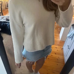 Vit stickad tröja med ribbade detaljer - Säljer en vit stickad tröja med ribbade muddar och nederkant. Perfekt för lager-på-lager och enkel att matcha med jeans eller kjol. Från & other stories!