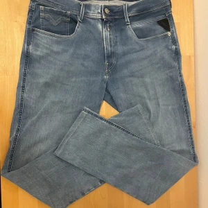 Ljusblå Jeans från Replay - Säljer ett par ljusblå jeansbyxor från Replay i modellen Anbass Hyperflex. Byxorna är i storlek W34 L34 men sitter som L32. Skick 9.5/10. Hör av er vid minsta fundering😊priset går att diskutera.