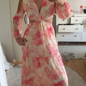 Långklänning  - Jätte snygg blommig långklänning med cut out vid midjan. Använd vid ett tillfälle, så den är som ny! 🩷🩷 Passar XS/S, 34-36