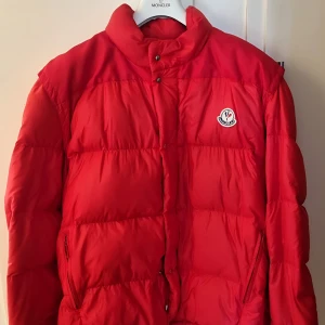 Moncler pufferjacka  - 🔥 Moncler-dunjacka i klassiskt rött – äkta vara, grymt pris! 🔥  Letar du efter en jacka som sticker ut och håller dig varm i vinter? Då har du hittat rätt! Det här är en original Moncler – röd, snygg och i gottskick. Perfekt för stan, fjällen eller vardagslyx.  🧥 Äkta Moncler – köpt via Vestiaire Collective (faktura finns). 💎 Sparsamt använd – mycket bra skick. 💯 Premiumkänsla – stilren, varm och klassisk. 💸 Du slipper nypriset – få lyx till bättre pris.  👉 Säljer den bara för att jag rensar gar