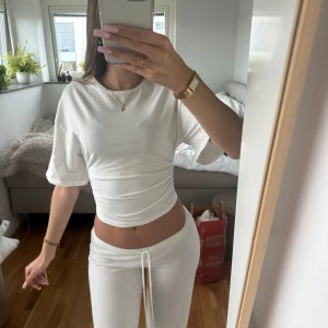 Vit croppad topp med snörning - Säljer en vit croppad topp i mjukt bomullsmaterial från Gina. Toppen har korta ärmar, rund halsringning och snygg snörning i midjan som ger en smickrande passform. Perfekt för dig som gillar en clean och fräsch stil. Ursprungspris 260kr. Tröjan är aldrig använd därav priset. 