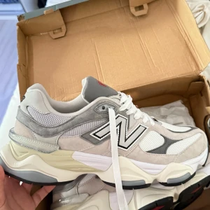 New Balance 9060 sneakers vit/grå - Snygga New Balance 9060 sneakers i vitt och grått med chunky sula och coola röda detaljer undertill. Helt nya och oanvönda i storlek 43. Pris kan diskuteras vid snabb affär!