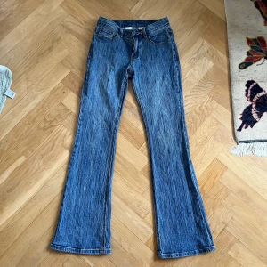 Blå bootcut jeans Brandy Melville - Säljer ett par blå bootcut jeans från J.Galt (Brandy Melville) med snyggt tvättad look och markerade vertikala ränder. Klassisk femficksmodell med bälteshällor och dragkedja. Jeansen är i stretchig bomull. 