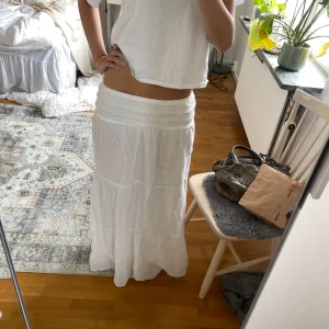 Vit långkjol från Gina Tricot - Säljer denna jätte söta långkjolen köpt på ginatricot. Använd ca 2 gånger därav nyskick. Jätte skönt material. Jag är 173 cm lång och den är inte för kort på mig. Hur lågmidjad man vill ha den går att justera själv.😊