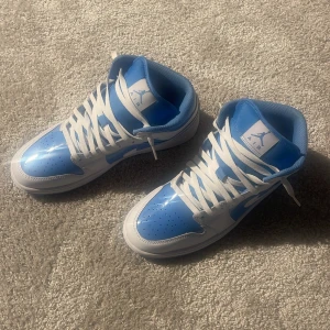 Nike Air Jordan 1 Mid UNC blå/vit - Säljet mina Jordans för att jag använder aldrig dem. Skick 10/10 har aldrig använt dem ute. Dem är äkta. Pris kan diskuteras men va rimlig