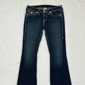 True Religion Vintage Joey Jeans - Super snygga vintage utsvängda jeans från True Religion i modellen Joey Big T. Stl 28. De är 37 cm i midjan med 81 cm innerbenslängd. 
