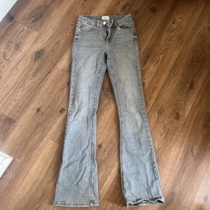 Grå bootcut jeans från Only - Grå jeans från Only med klassisk femficksdesign och bootcut-ben. Jeansen har normal passform och är tillverkade i mjukt bomullsmaterial med en lätt tvättad look. Perfekta för dig som gillar en avslappnad men ändå snygg stil.