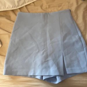 Kjol-shorts - Ser ut som en kjol men är egentligen shorts. Har dragkedja på sidan. Aldrig använd men etiketten är borttagen 