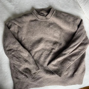 Beige stickad tröja från Pull&Bear - Mysig beige stickad tröja från Pull&Bear i storlek S. Tröjan har en klassisk rund halsringning, ribbade muddar och avslut. 
