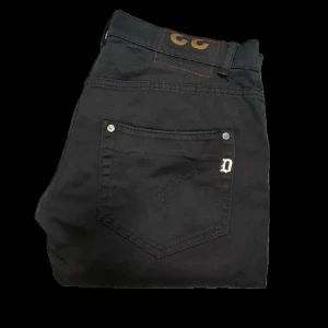 Dondup Jeans - Säljer dessa svarta dondup jeans! Jeansen är i bra skick, enda felet är att en sån här där man har bältet har lossnat i ena änden vilket ej påverkar användningen. Där av priset. Bortsett från de är de sjukt bra skick! Size 33. Skriv vid funderingar. 