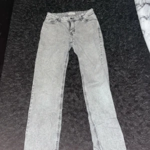 Grå jeansbyxor - Snygga grå jeansbyxor med en klassisk design. De har en dragkedja och knappar framtill. Perfekta för en avslappnad stil.