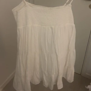 VIT KLÄNNING FRÅN ZARA - Säljer en söt vit klänning med smockdetaljer upptill. Klänningen har en luftig och avslappnad passform, perfekt för varma dagar. Den är gjord i ett lätt och bekvämt material. Kommer inte till använd längre men är perfekt nu till sommaren!💗