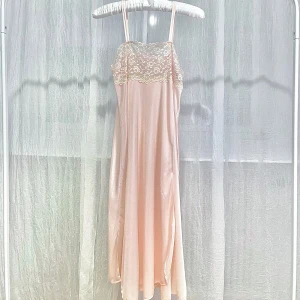 Ljusorange klänning med spetsdetaljer - Elegant ljusorange klänning med vacker spets upptill och flödande passform. Den är ”see through” vid brösten (se sista bild) så passar bäst som en nattlinne.