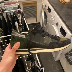 Phillipe model  - Snygga svarta sneakers från Philippe Model med gröna och silverfärgade detaljer. Skorna har snörning och en unik design med en kombination av olika material som ger en cool look. Skriv för fler frågor😃