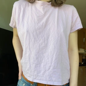 Ljusrosa t-shirt från NA-KD - Säljer en ljusrosa t-shirt från NA-KD i storlek S. Den är kortärmad och har en klassisk rund halsringning. Perfekt för en avslappnad stil. 🌸