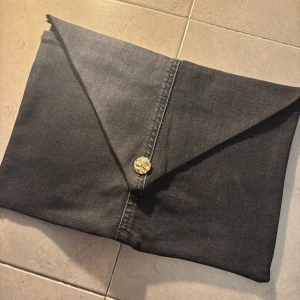 Datafodral i jeans - Unikt datafodral i svart jeanstyg med guldknapp. Insidan är fodrad med ett mjukt silkestyg för extra skydd. Passar 13 tum (vanlig skoldator)