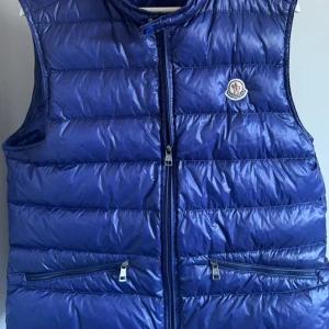 Moncler Gui Väst - Moncler Gui Väst  Storlek: 4 (Ungefär M) Skick: 8/10, förutom flaws, se bild 2.  Nypris: 9260kr Pris: 2600kr  Frakt: (Hemlevererat spårbart)📦  Tveka inte att höra av dig vid minsta frågan!