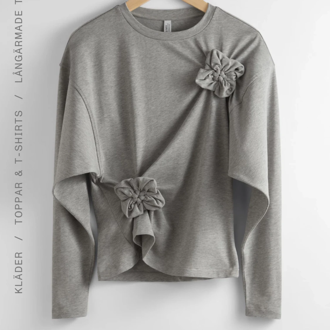 Grå långärmad topp med blommiga detaljer