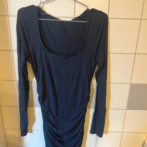 Mörkblå långklänning (soft touch) - Elegant mörkblå långklänning med långärmad design och en åtsittande passform. Perfekt för en stilren look. Aldrig använd.