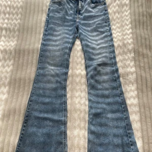 Blå bootcut jeans från Pull&Bear - Snygga blå bootcut jeans från Pull&Bear. De har en klassisk femficksdesign och är tillverkade i ett bekvämt denimtyg. 