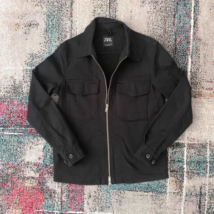 Svart overshirt från Zara - Snygg svart overshirt från Zara med dragkedja och två bröstfickor med lock. Jackan har långa ärmar med knappstängning vid ärmsluten. Perfekt för lager-på-lager-stil och passar till många olika outfits. Skriv till om ni är intresserade eller har några frågor!