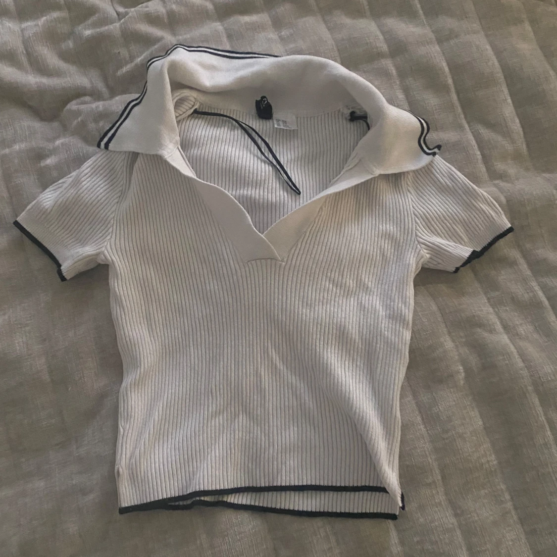 Vit ribbad pikétröja med svarta detaljer