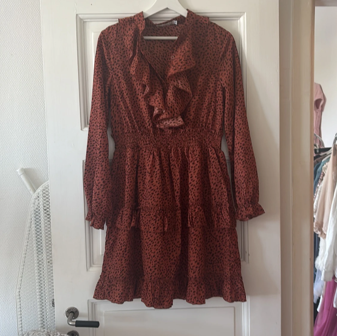 Rödbrun klänning med volang och prickigt mönster