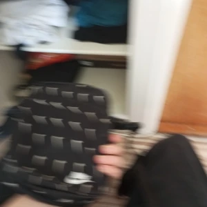 Svart axelväska från Nike - Säljer en svart axelväska från Nike med vitt mönster och logga på framsidan. Väskan har justerbar rem och är perfekt för att bära med sig det viktigaste. Snygg och sportig design!