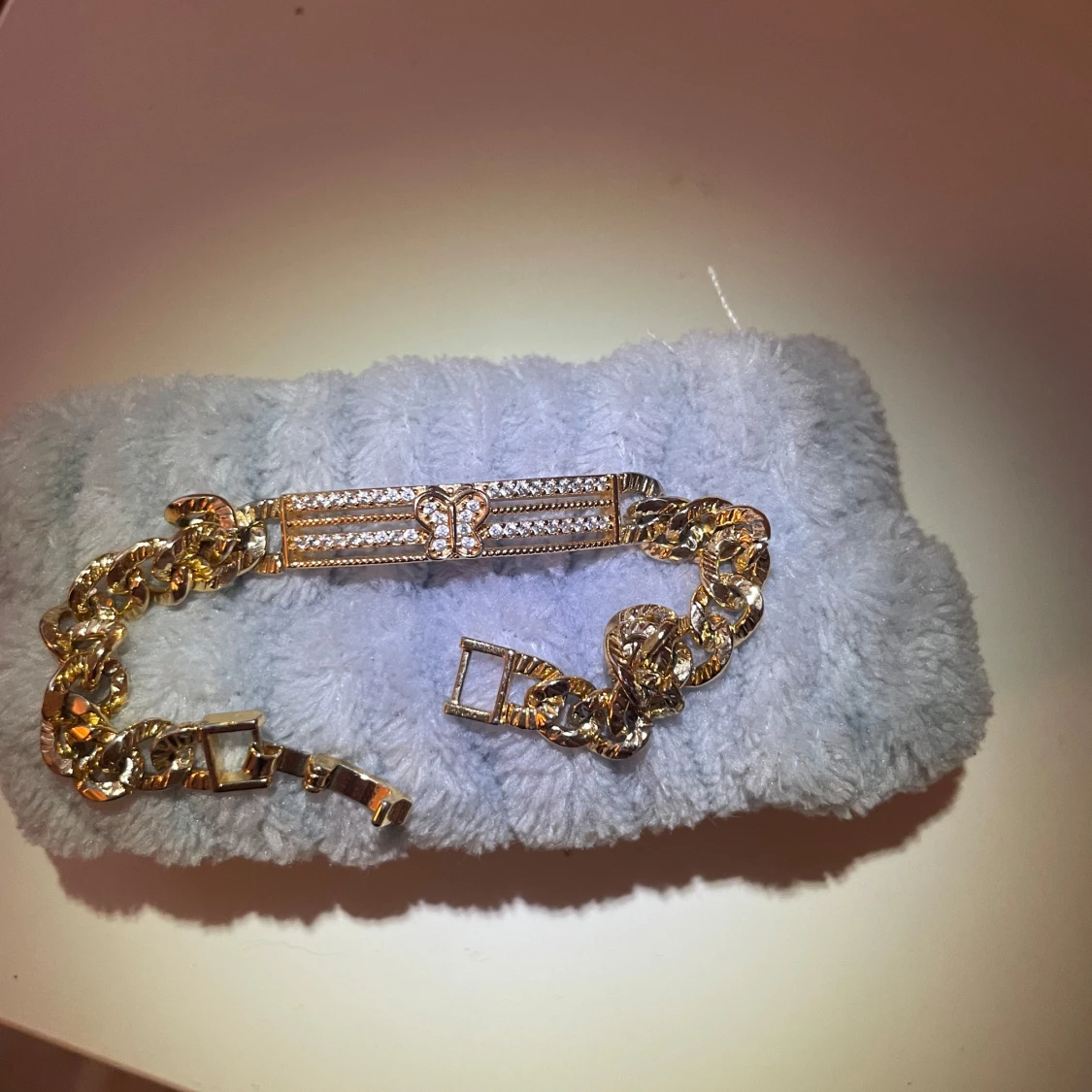 Guldfärgat armband med fjärilsdetalj