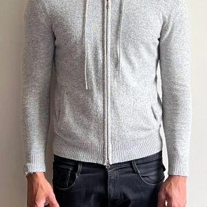 Grå Kashmir hoodie från Barlucio ( Storlek XS ) - Snygg grå kashmir zip hoodie från Barlucio. Lite knoprig därför till ett billigare pris.  Btw säljer jag både denna och en mörkblå som en kombination för den som är sugen finns ja i DM.  - Modellen är 180 väger cirka 70kg. Obs: Den sitter som S