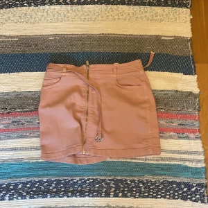 Rosa kortkjol med bälte och dragkedja - Snygg rosa kortkjol med cool dragkedja framtill och matchande bälte som kan tas av. Sitter precis som man vill. Från Zara. Nästintill oanvänd