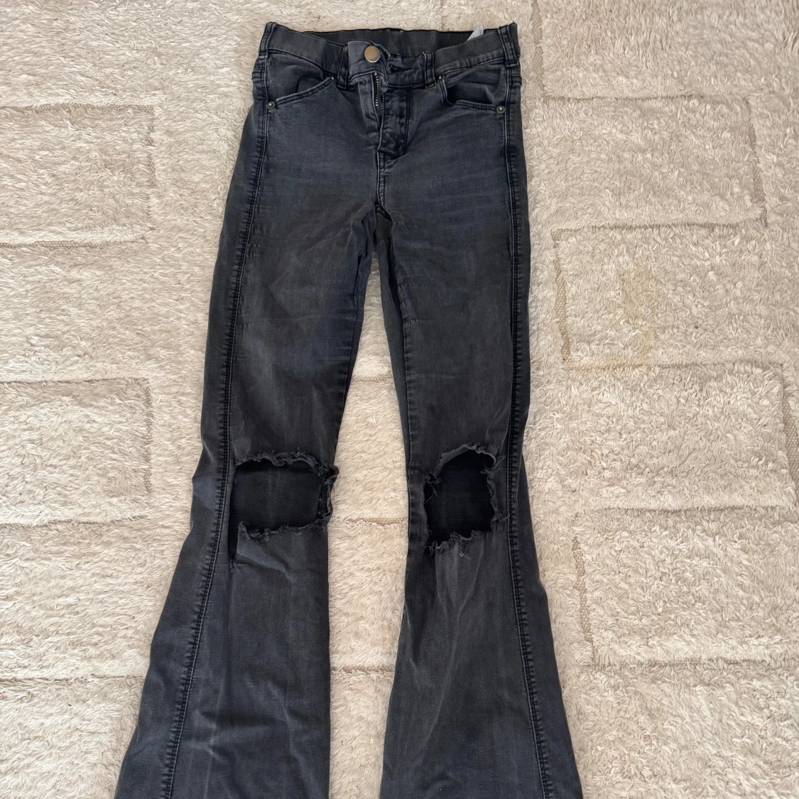 Svarta bootcut jeans med slitna knän